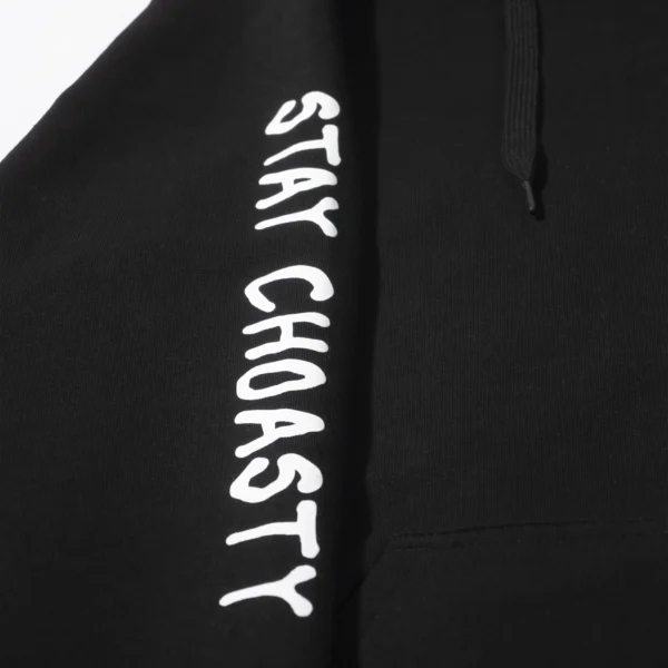 Showing a closeup of the black sweaters sleeve. Our text logo saying "staychoasty" running down the sleeve