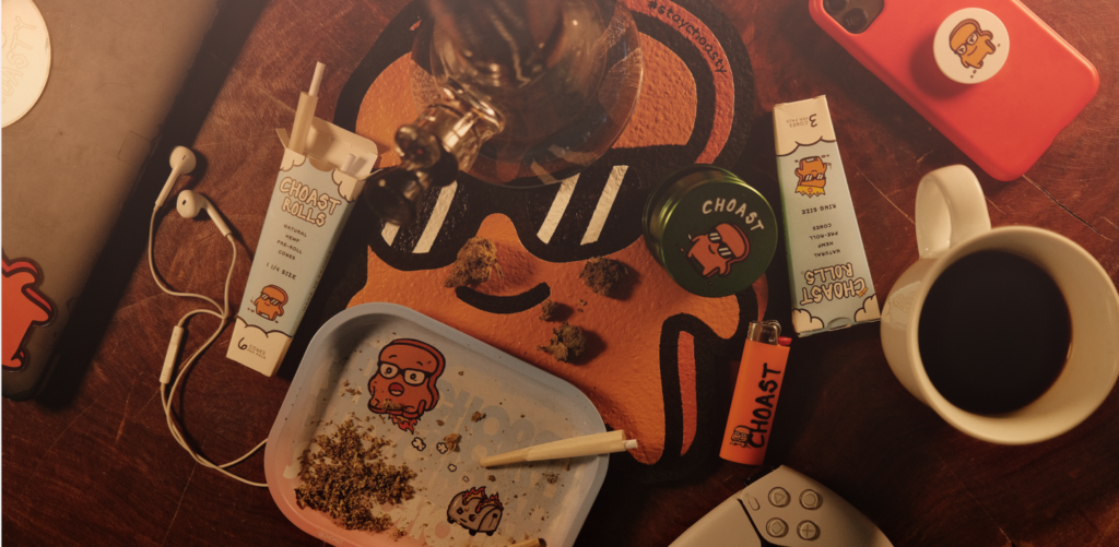 Our choast smoke accessories laying on the table. Showing our different products which are; choast pre roll cones, the choast grinder, stay choasty rolling tray, and the choast dab mat. Two different variations for our rolling paper sizes, 1 1/4 and king size.